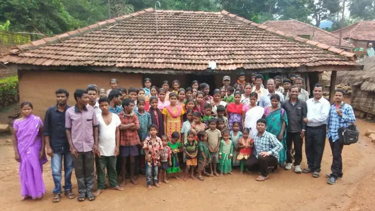 large group of people gathered outside village building