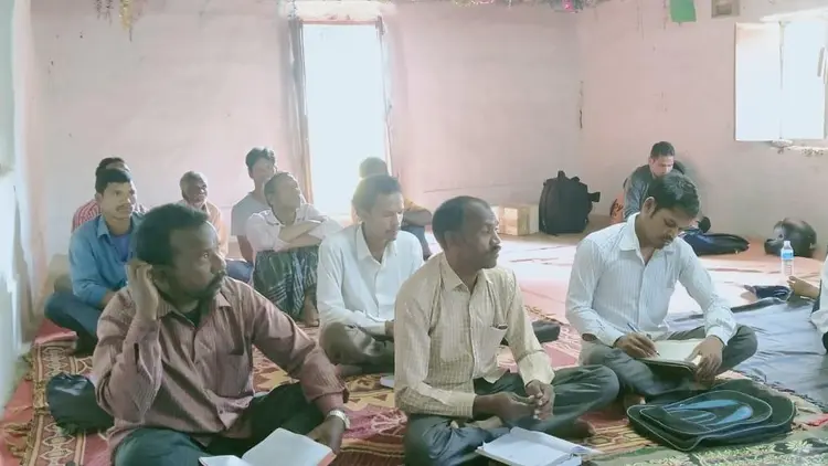 group of men sat on the floor in a meeting