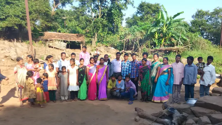 large group of people gathered outside in rural setting