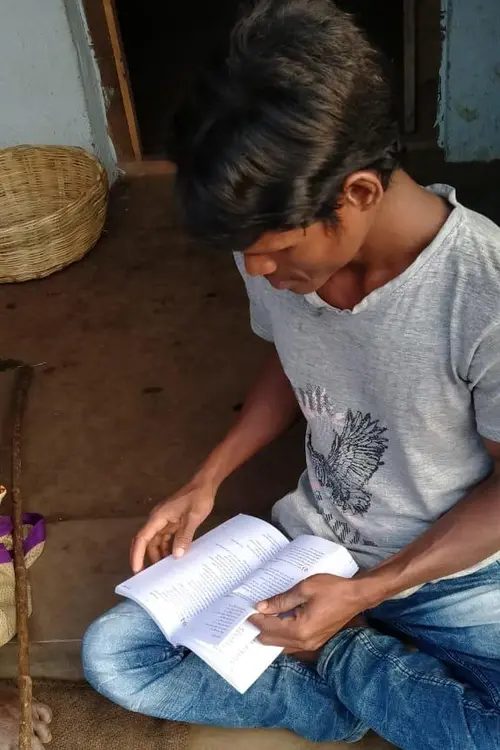 man sitting on the floor reading a Bible