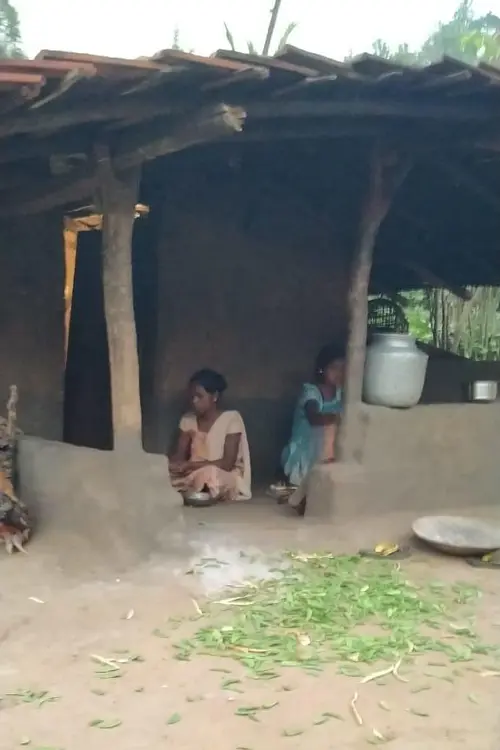 2 women sitting at the entrance of a house