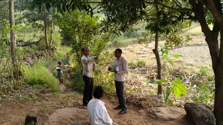 3 men talking under a tree