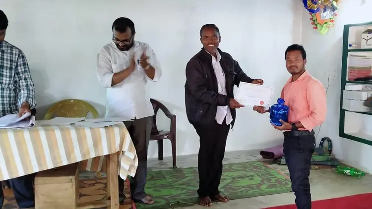 man receiving a certificate in a public ceremony